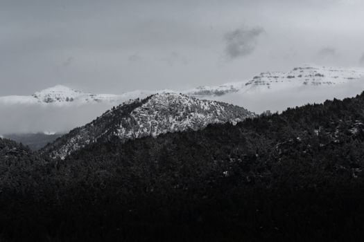 A serene, snow-covered mountain landscape captured in monochrome, showcasing nature's tranquility.