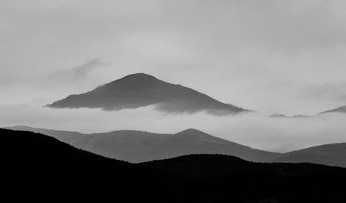 Grayscale Photo of Mountain Ranges and Clouds