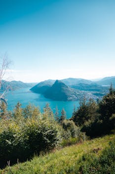 Breathtaking view of Lugano city and lake framed by green hills in Switzerland.