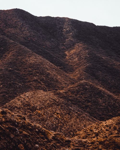 Free Capture the serene beauty of a vast brown mountain landscape during dusk. Perfect for nature lovers. Stock Photo