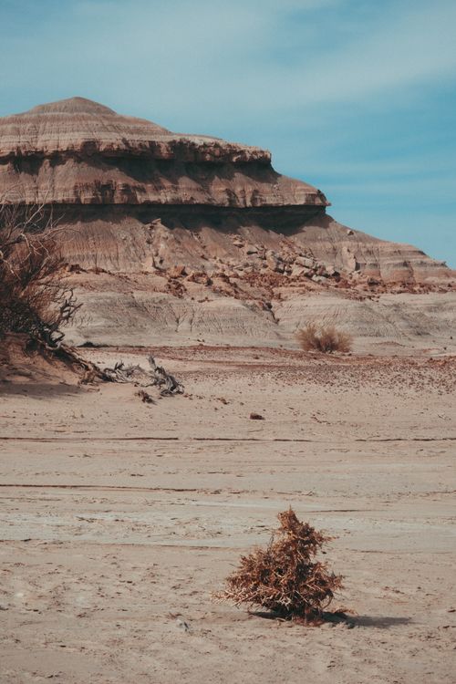 Free Captivating view of a desert landscape with a striking rocky formation under a blue sky. Stock Photo