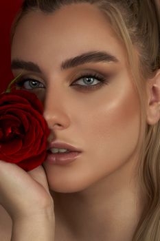Close-up portrait of a woman holding a red rose in Karaj, Iran.