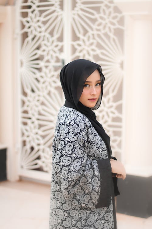 A Woman in Black and White Abaya Looking at the Camera