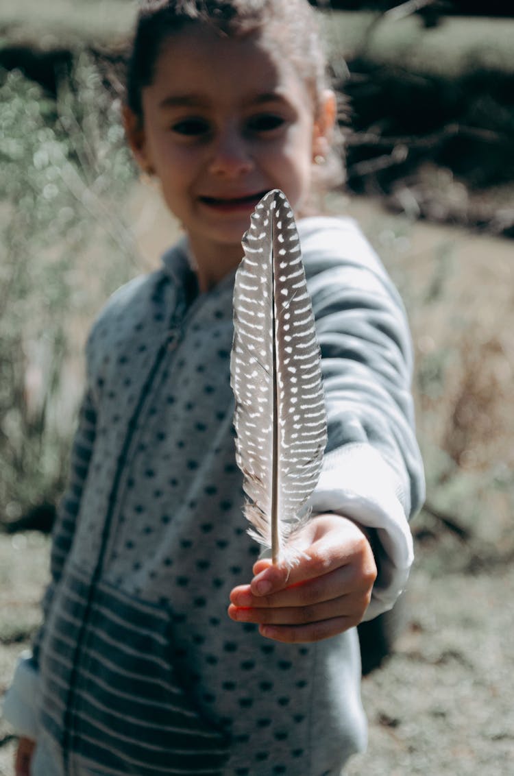 Girl Holding A Feather