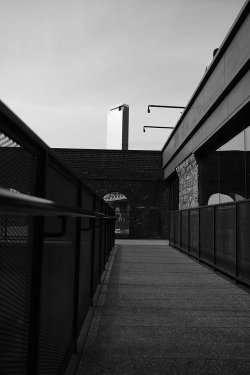 Free Black and white urban scene featuring a bridge with modern architecture and reflections. Stock Photo