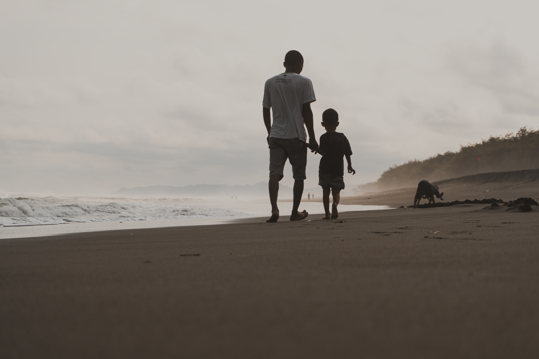 A touching scene of a father and son walking along the beach in Kebumen, Indonesia.