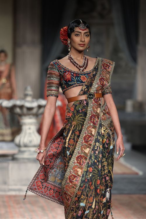 Free Portrait of a fashion model showcasing a traditional Indian saree during a fashion shoot. Stock Photo