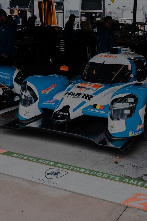 Free High-performance LMP3 racing car parked in a garage at a motorsport event. Stock Photo
