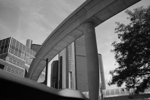 Grayscale Photography of a Bridge Near Concrete Buildings