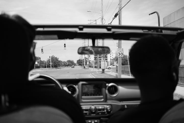 People Driving In Cabriolet Car On Street