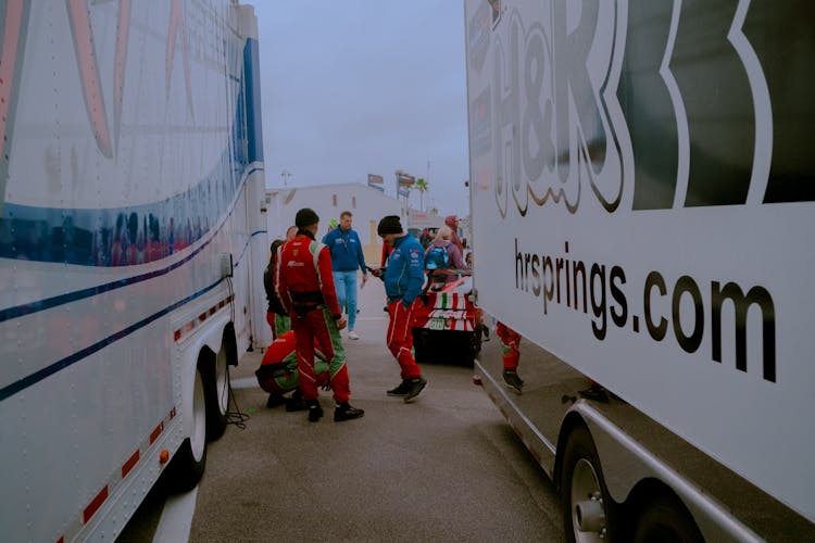 People Standing Near Parked White Trucks