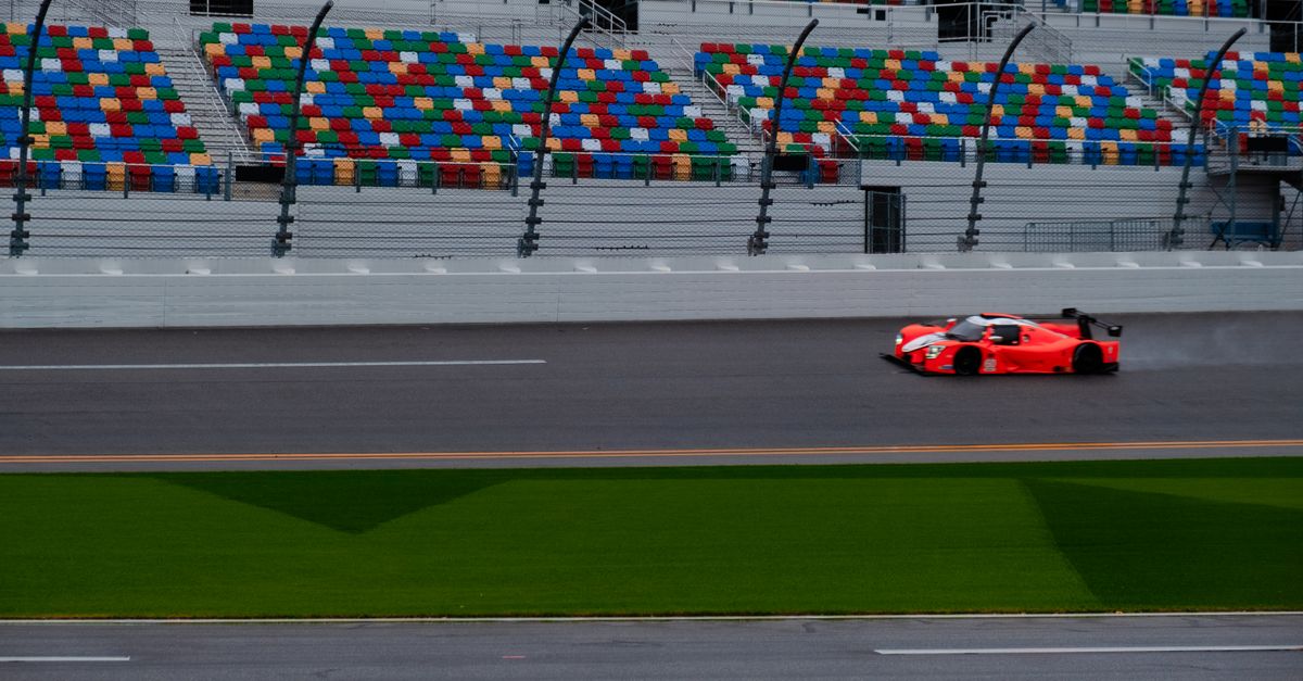 Exciting race car on the track against colorful stadium seating backdrop, showcasing speed and adren