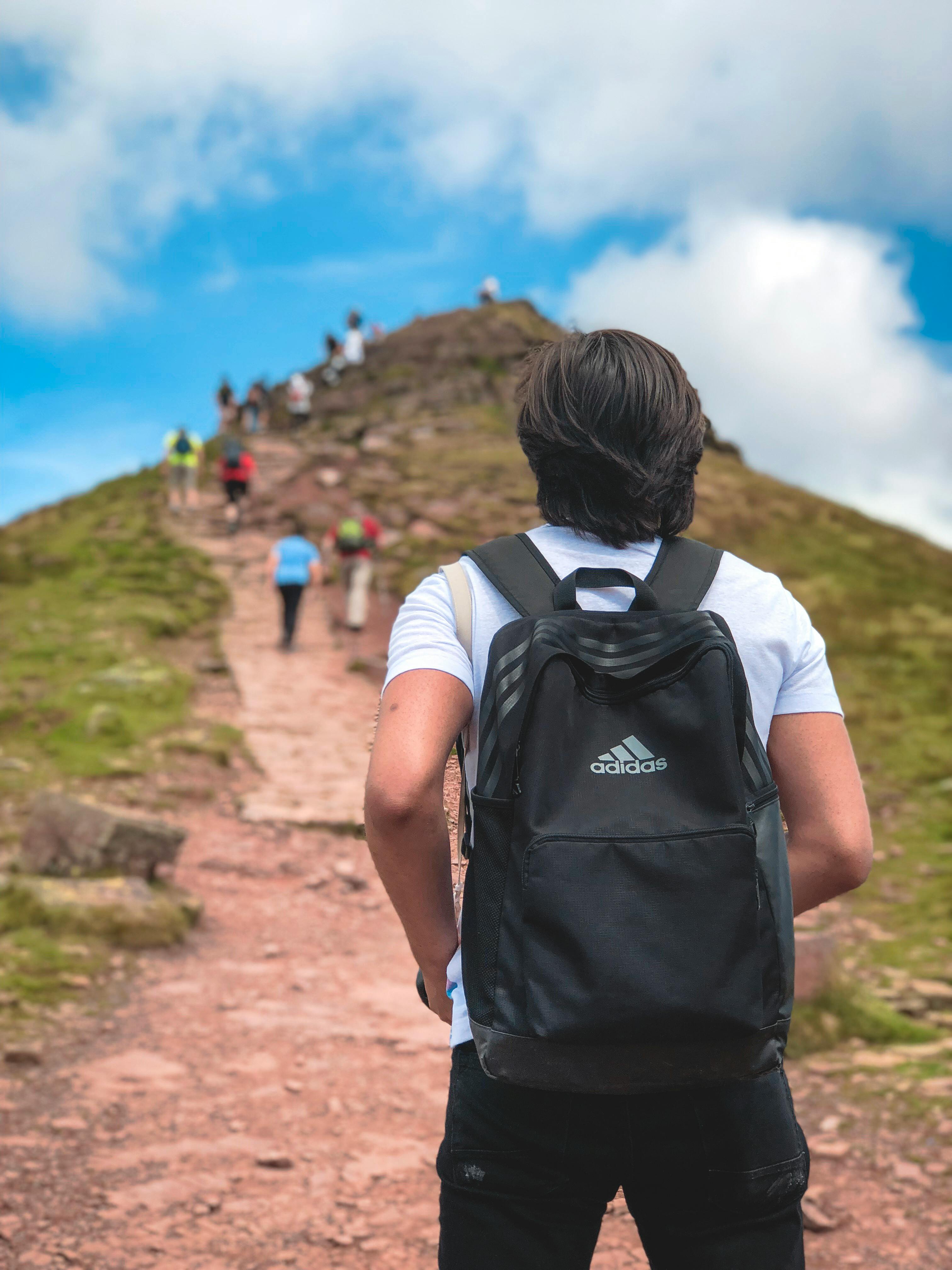 一个背着背包的男人正在风景秀丽的户外与他人一起远足