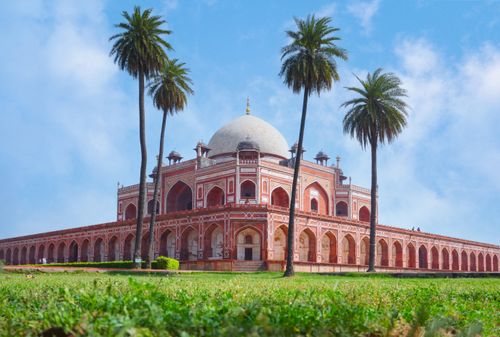 Free Humayun's Tomb surrounded by palm trees under a clear blue sky in New Delhi, India. Stock Photo