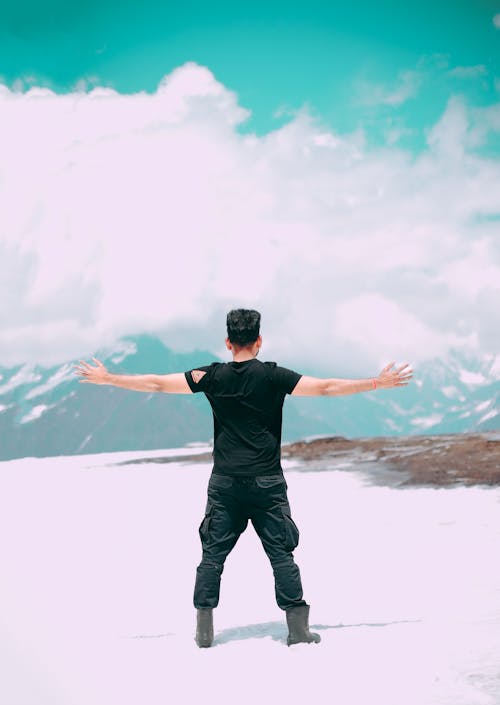 Man Standing on Snow Covered Ground