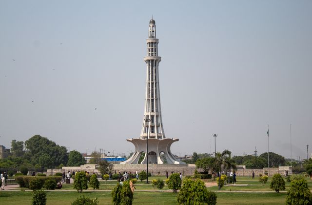 Stunning daytime capture of Minar-e-Pakistan surrounded by lush greenery in Lahore. — arriving in Lahore