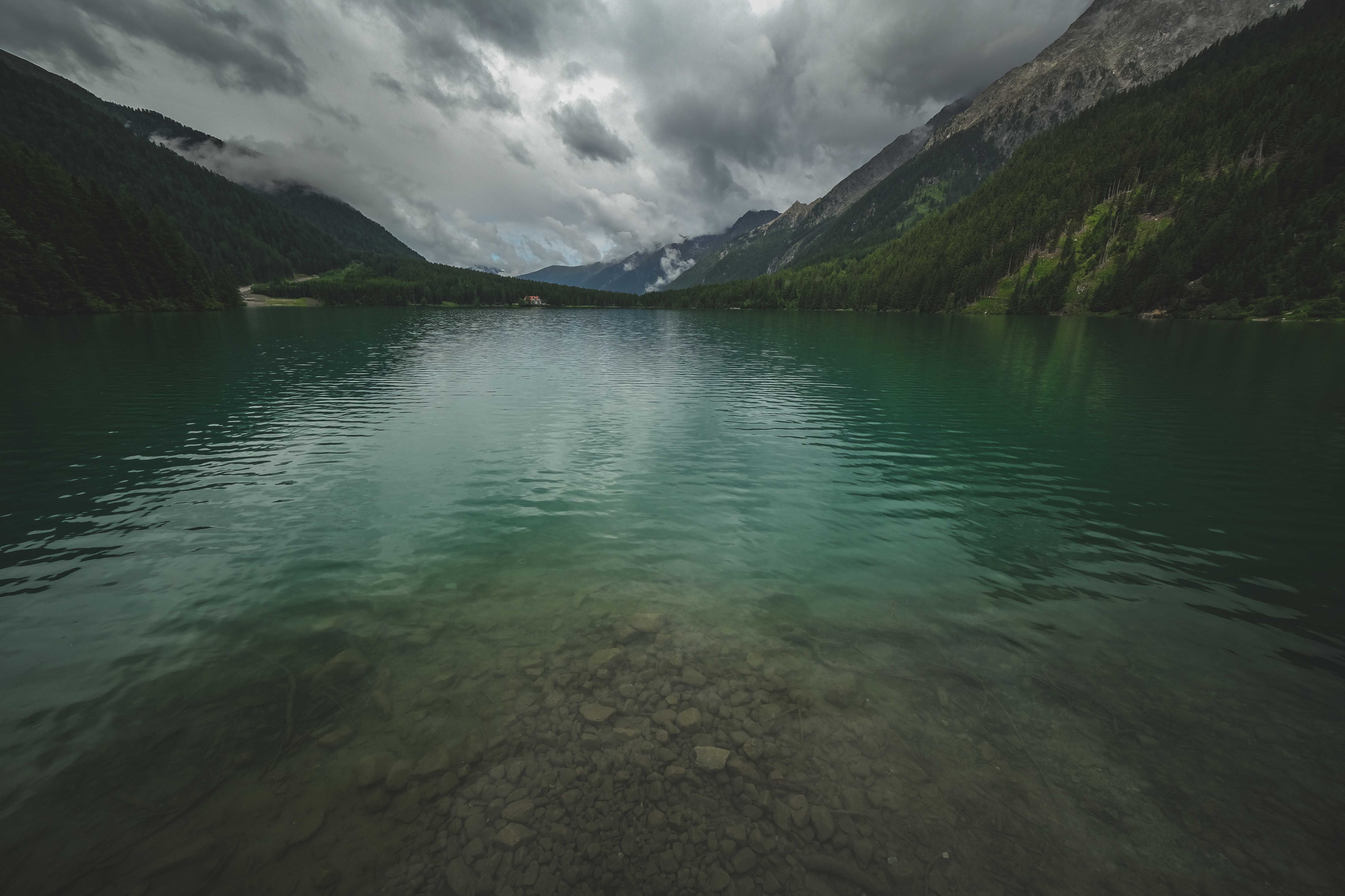 Green Lake Near Green Mountains Under Gloomy Sky · Free Stock Photo