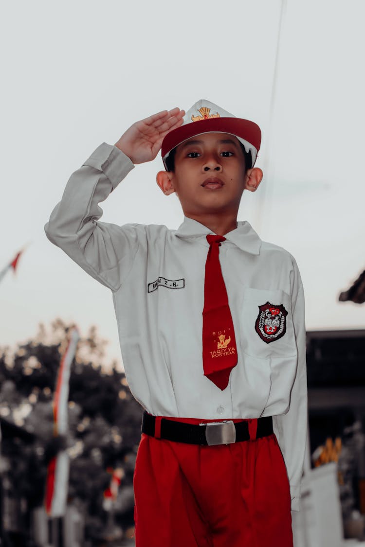 Small Boy Wearing Clothes In National Colors Saluting The Flag At The Celebration Of The Independence Day