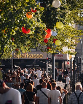 A lively crowd enjoys a festive urban scene in Hamburg adorned with colorful lanterns.