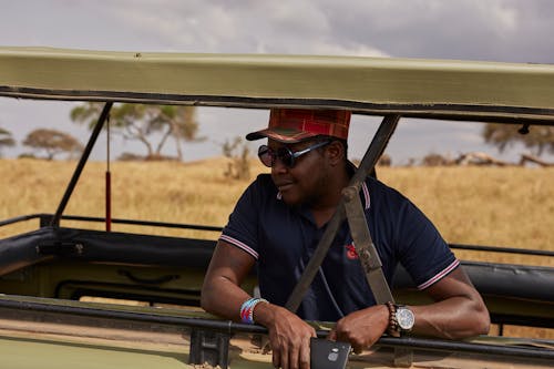 Gratis lagerfoto af afroamerikansk mand, bil, blå poloshirt