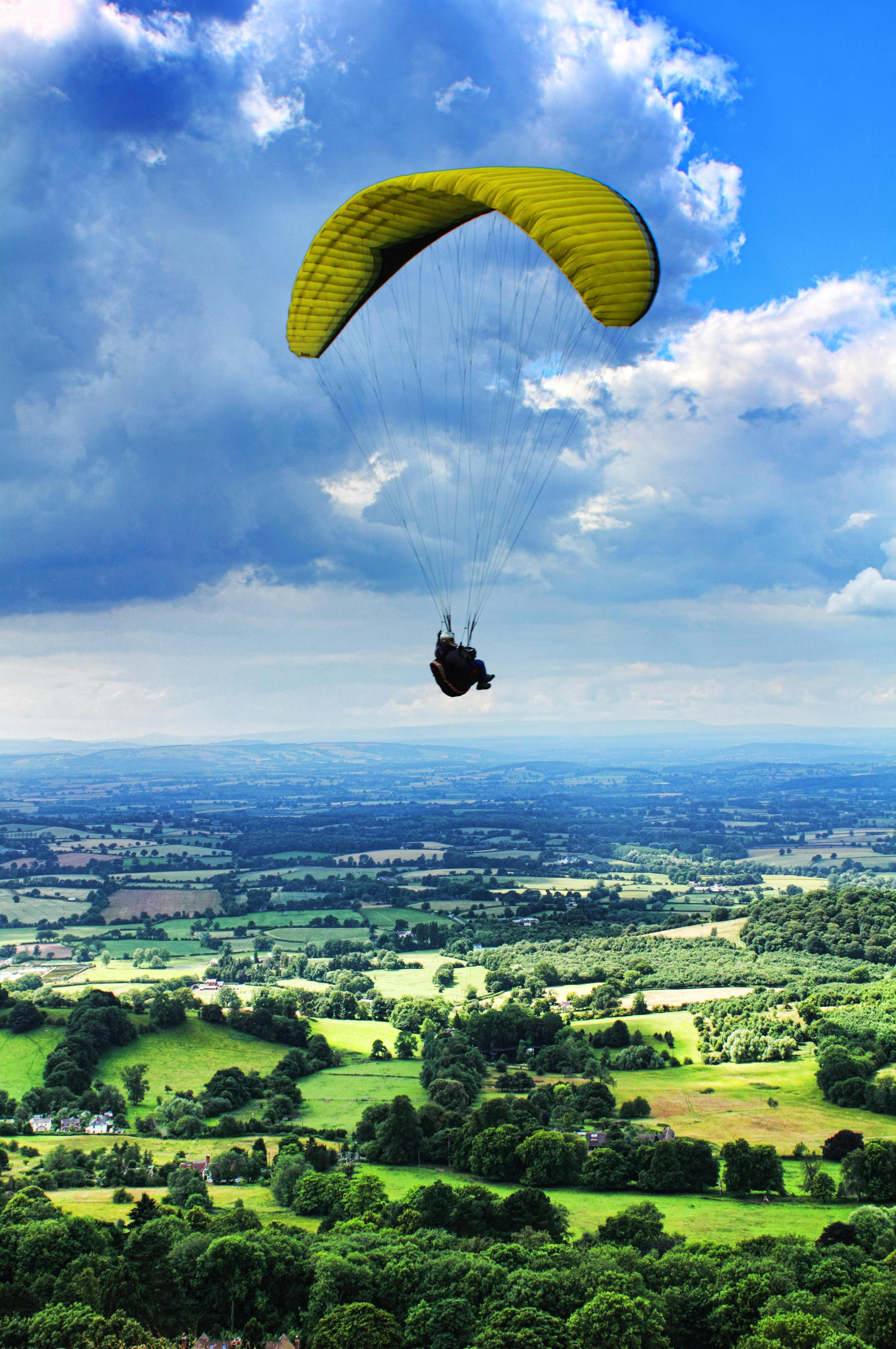 person paragliding under cloudy sky