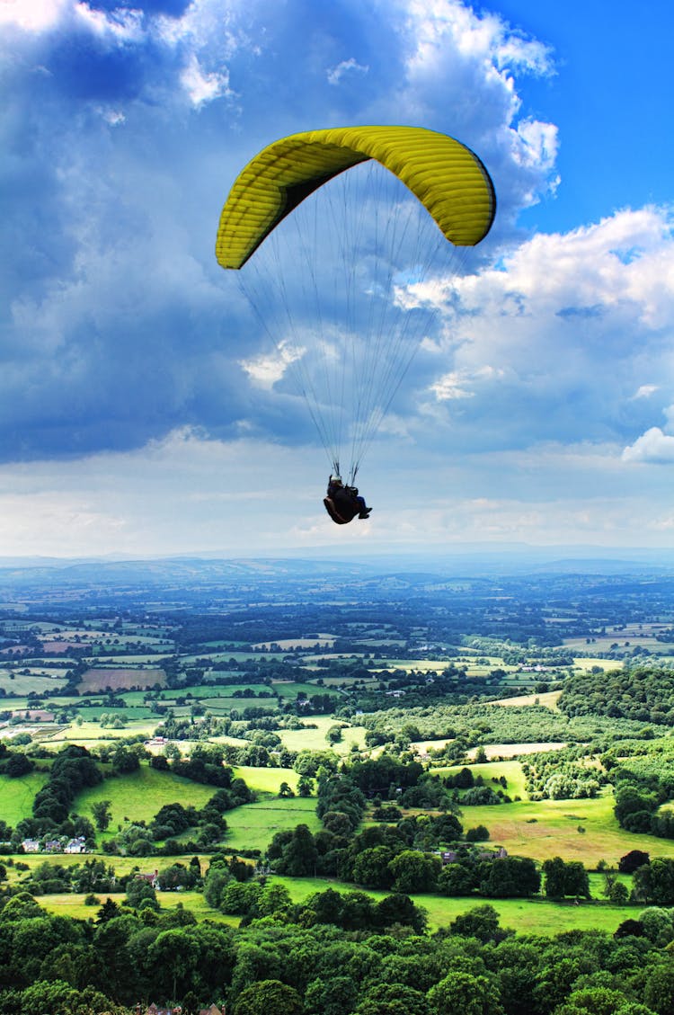 Person Paragliding Under Cloudy Sky