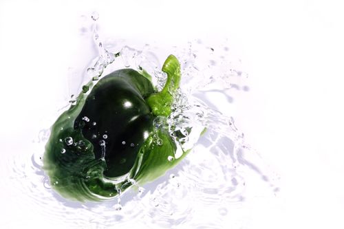 Free Dynamic shot of a green bell pepper splashing into water, highlighting freshness. Stock Photo