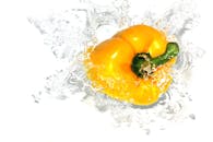 一张黄色甜椒以动态溅入清澈水中的惊人图像