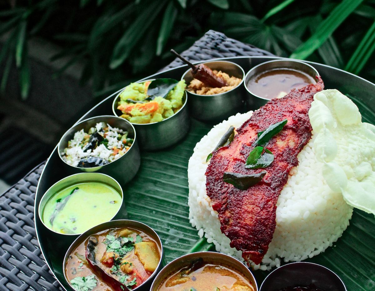 Kerala rice meal with curries and fried fish on a banana leaf