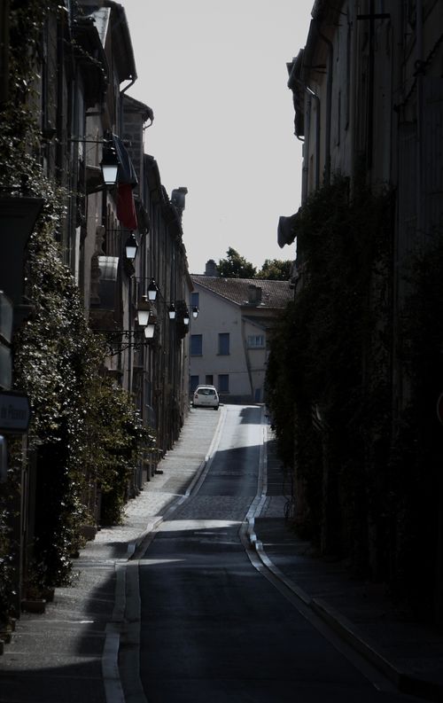 Free A shadowy alley in a European city with classic architecture and vintage streetlights. Stock Photo