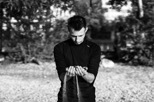 A Man Looking at the Sand on His Palm