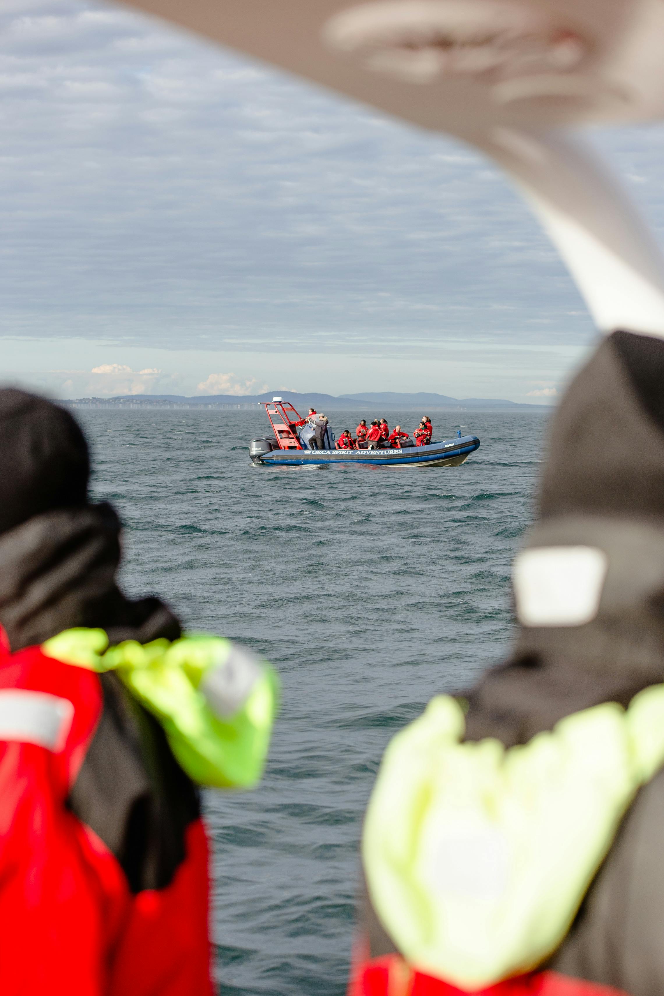 people sailing in a boat photographed from another boat