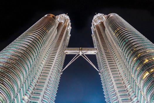 Stunning low-angle shot of the iconic Petronas Towers in Kuala Lumpur, Malaysia, illuminated against the night sky.