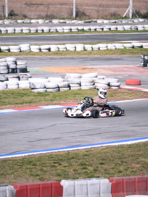 Free High-speed go-kart racing action captured on an outdoor track with tire barriers. Stock Photo