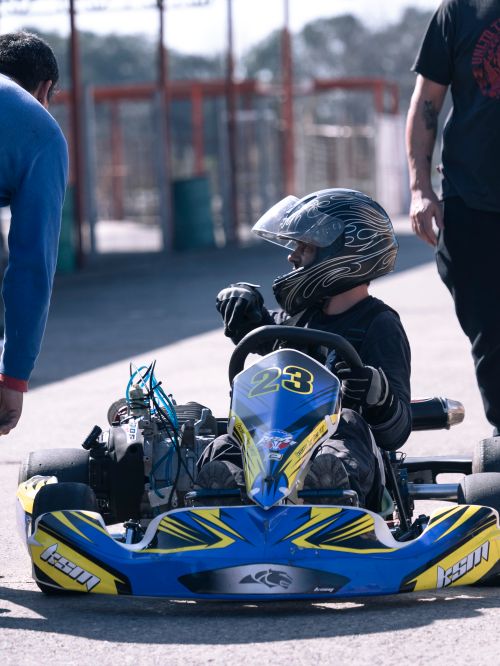 Free A go-kart driver in helmet and gear readies for a race on the track. Stock Photo