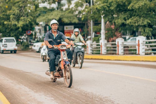 Mann, Der Motorrad In Der Straße Reitet