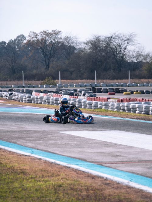 Free A go-kart racer navigates a turn on an outdoor track, showcasing speed and adrenaline. Stock Photo