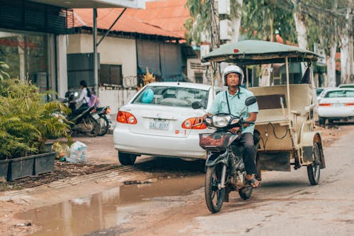 Người đàn ông đi Xe Máy Gần ô Tô Màu Trắng