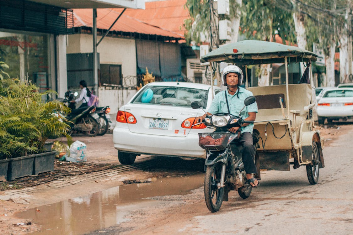 Man Riding Motorcycle Near White Car