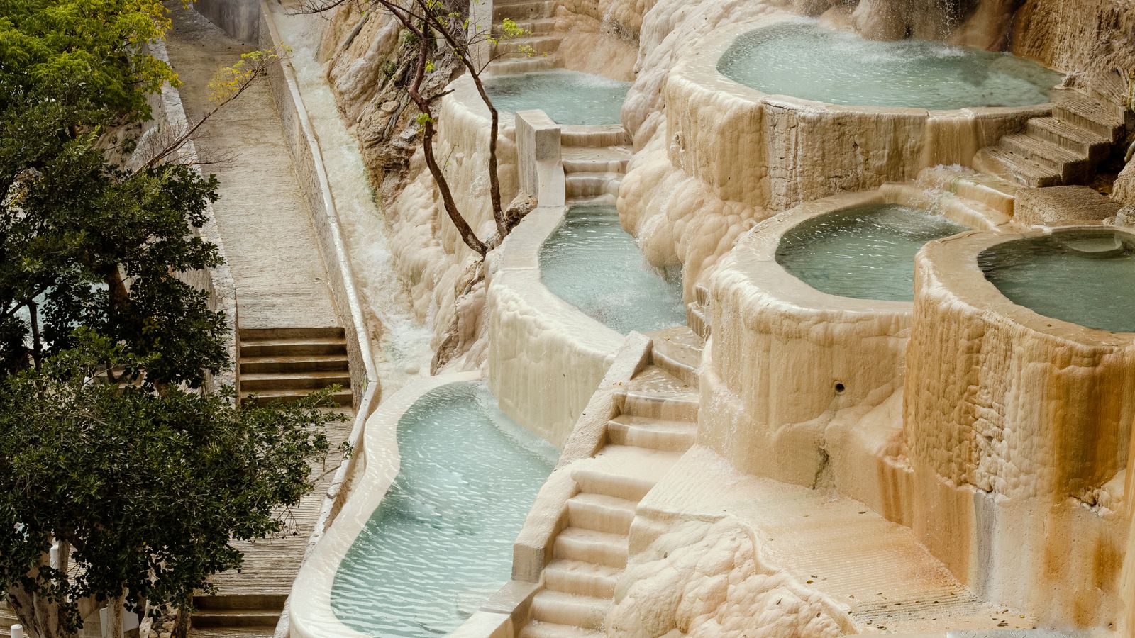 Terraced natural hot spring pools among rock formations