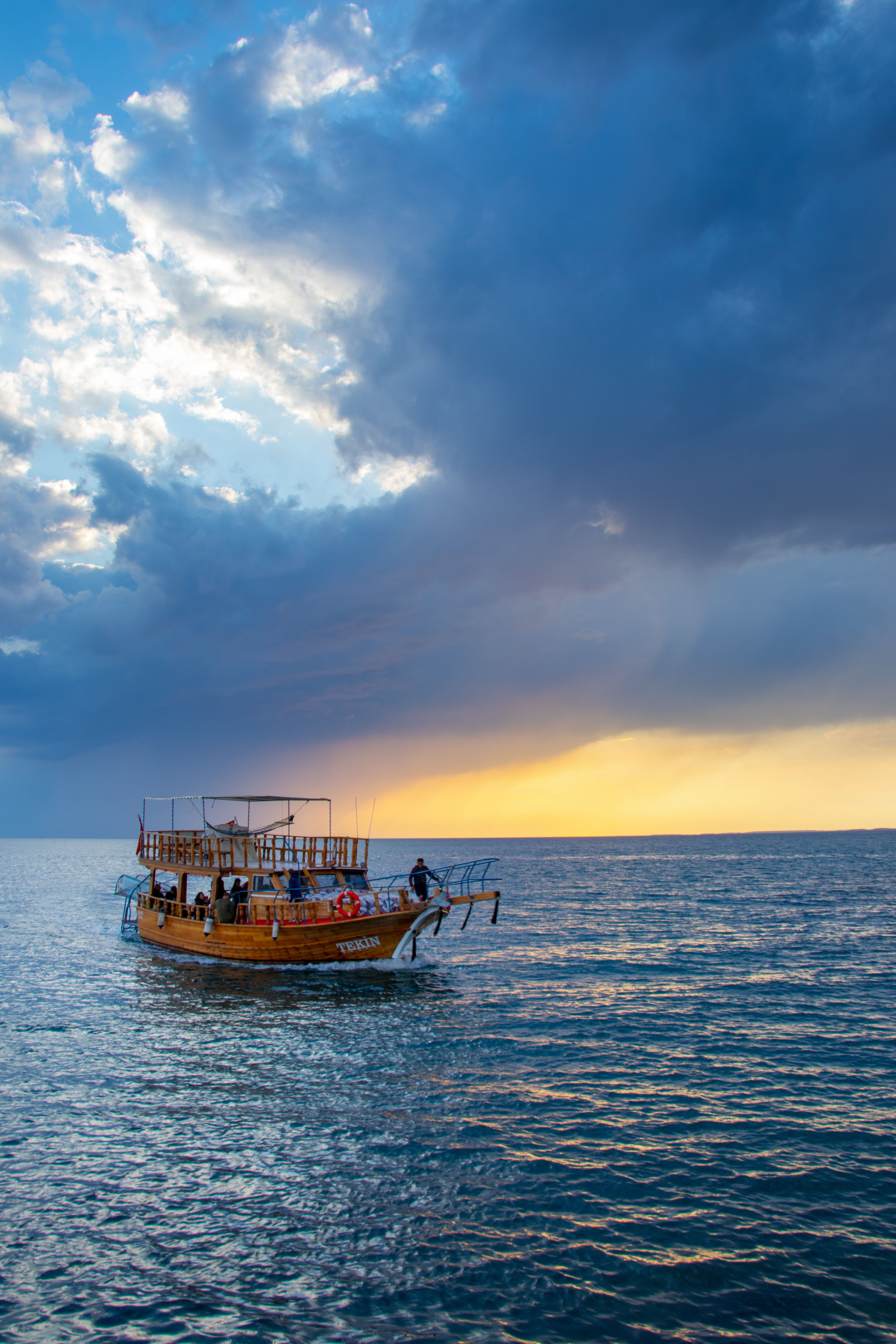 A Wooden Boat Sailing on the Sea Under Cloudy Sky · Free Stock Photo