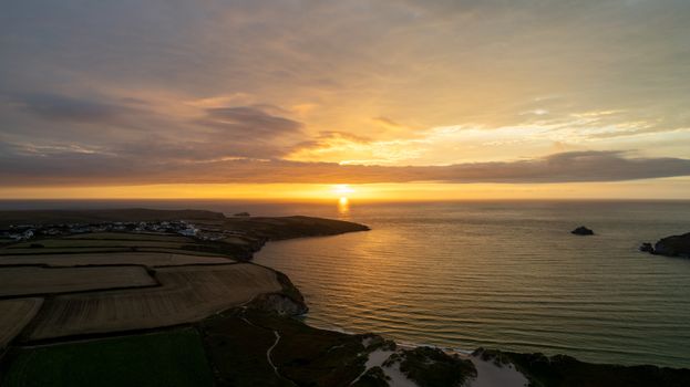 A stunning sunset view over Cornwall's coastline and fields, captured with a drone.