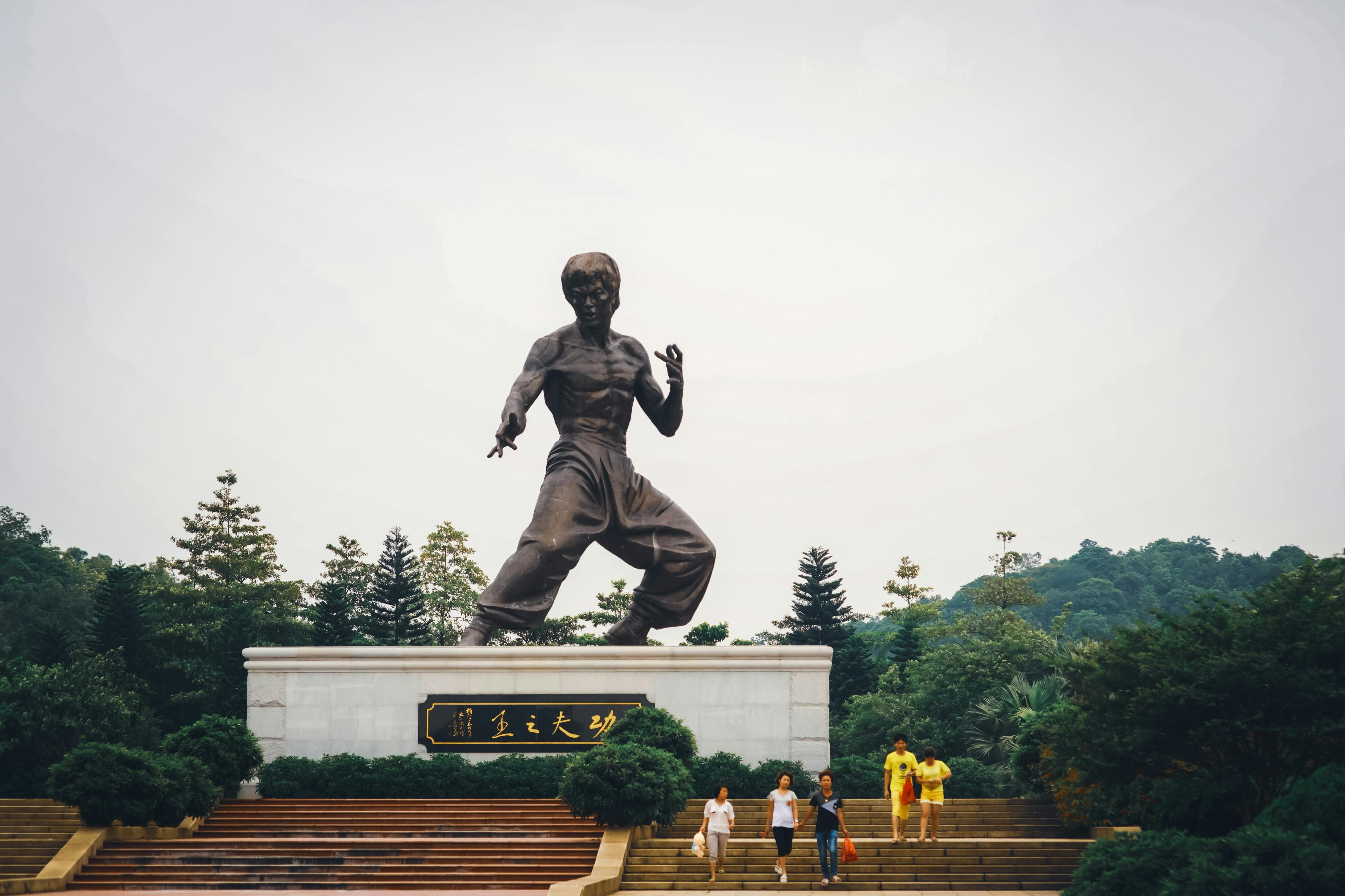 People Near the Statue of Bruce Lee