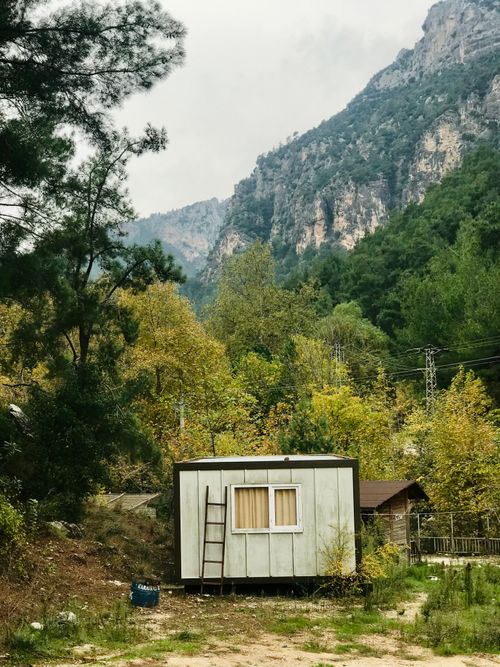 Free A solitary rural cabin set against lush, mountainous scenery in summer. Stock Photo