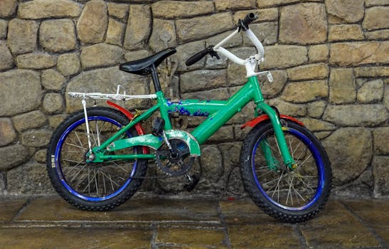 Colorful vintage bicycle leaning against a rustic stone wall, creating a nostalgic scene.