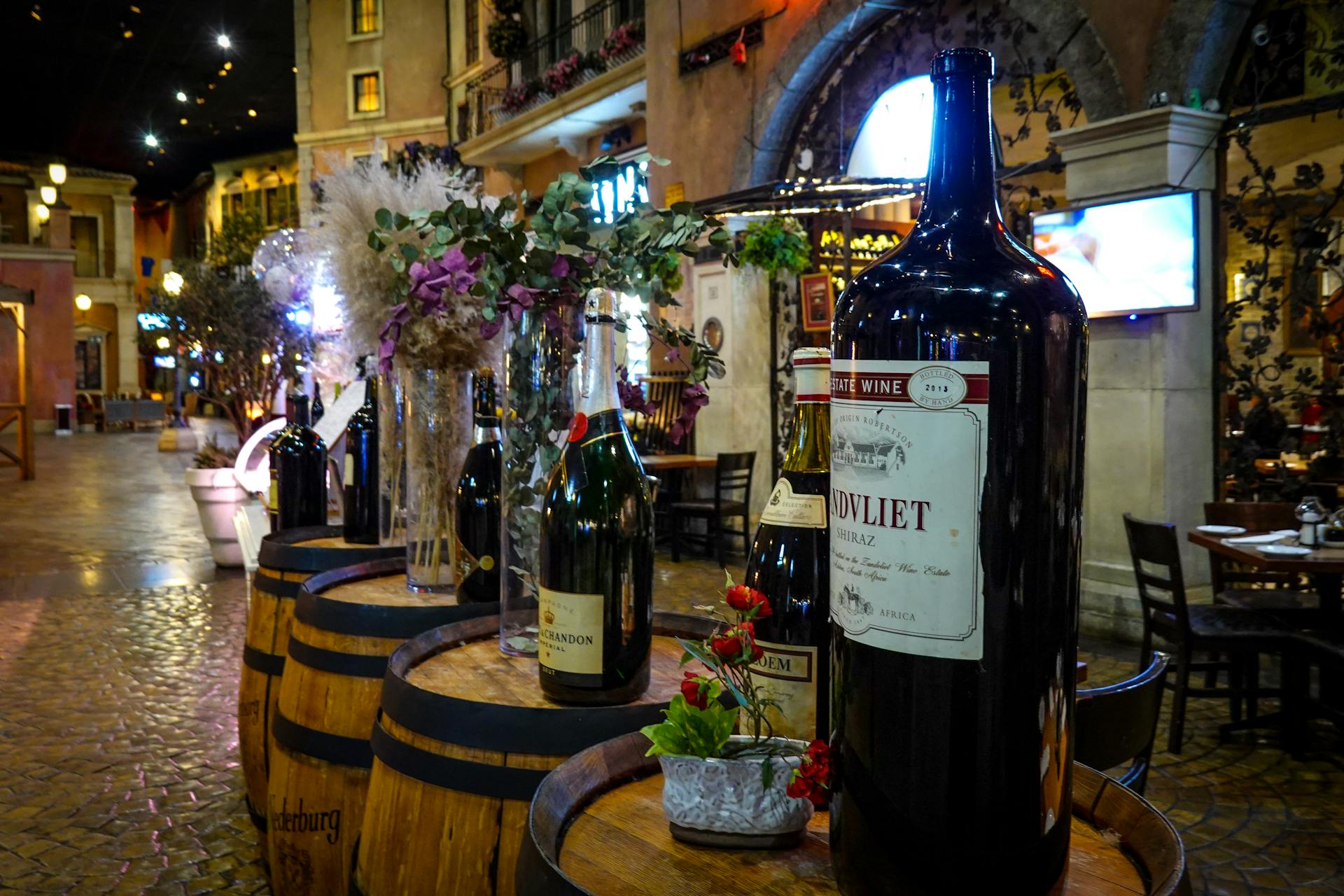 Charming indoor setting showcasing wine bottles and wooden barrels in a rustic vibe.