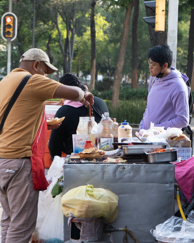 People Cooking Food On Outdoor Barbecue