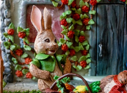 Free Colorful Easter bunny figurine surrounded by flowers, evoking a spring garden vibe. Stock Photo