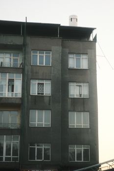 Close-up view of an apartment building facade showcasing multiple windows in an urban setting.
