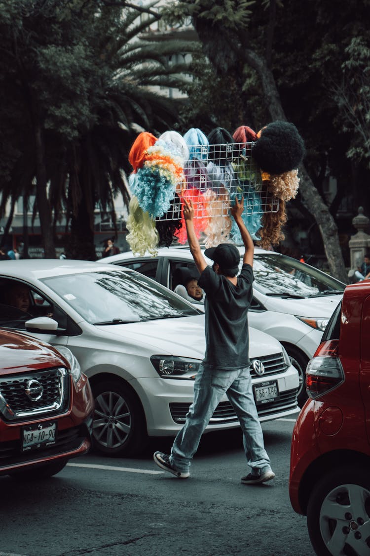 A Man Selling Hats And Wigs On The Street